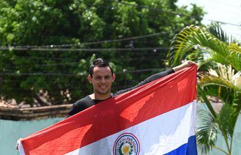 José Ariel López tras su llegada a Asunción exhibe su bandera paraguaya que lo acompañó en todo el viaje.