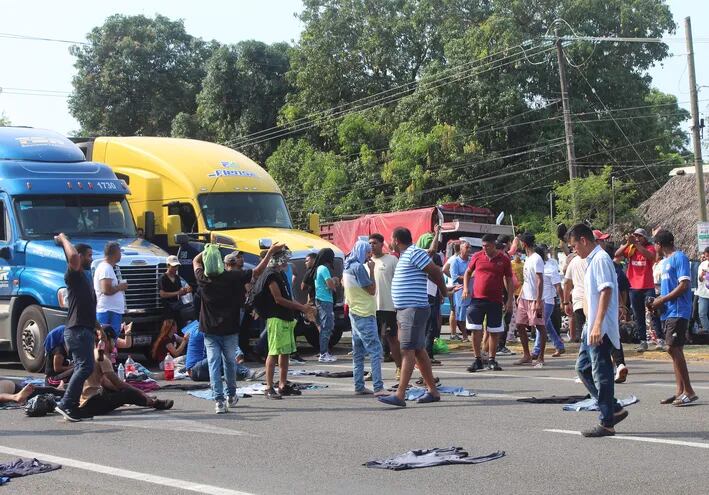 Caravana de migrantes bloquea carretera en sur de México para exigir visas.