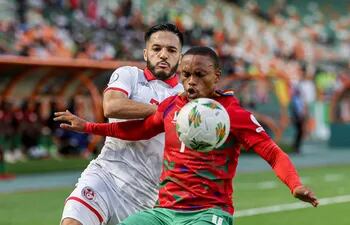 Riaan Hanamub (d), de Namibia, disputa el balón con Wajdi Kechrida, de Túnez, durante el partido jugado ayer en Costa de Marfil.