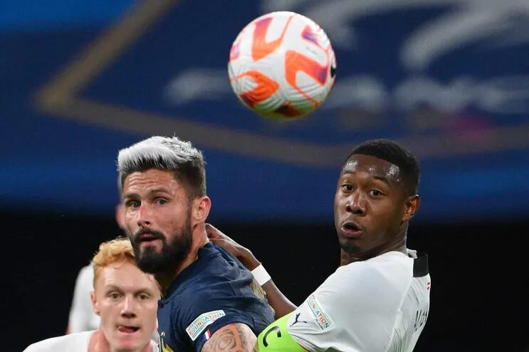 Olivier Giroud y David Alaba tienen en la mira el balón durante el duelo de ayer entre Francia y Austria.