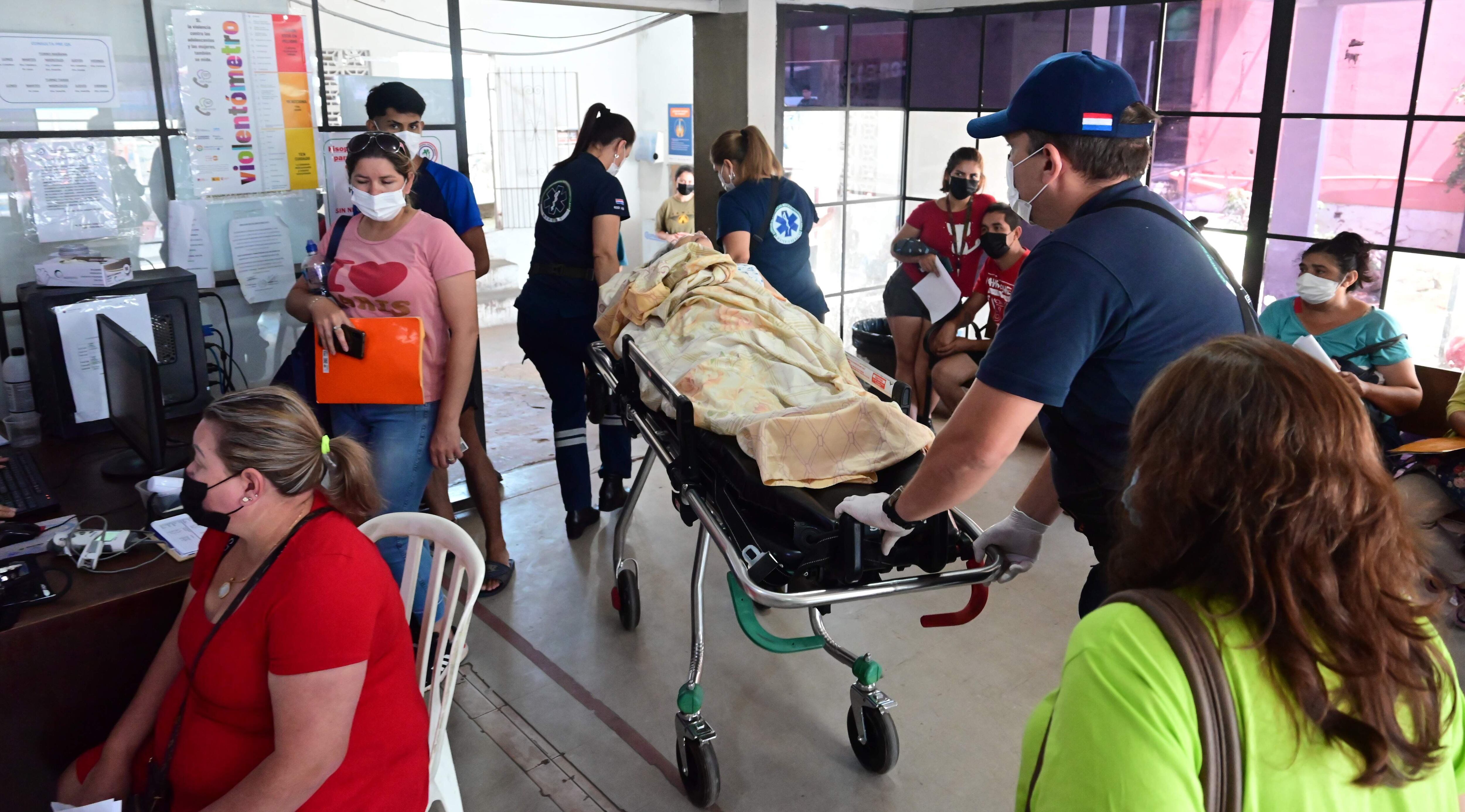 Un paciente trasladado en camilla pasa por el área de urgencias en medio de los pacientes que esperan atención en el Hospital de Barrio Obrero. 