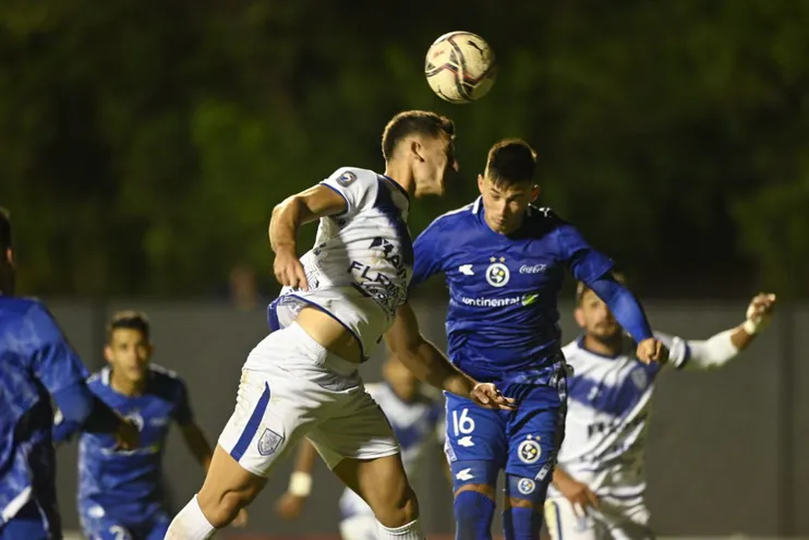 Nicolás Morínigo (i) triunfa en el salto para conectar el balón en la victoria del Sportivo Ameliano sobre Sol de América por la jornada 20 del torneo Clausura 2022 del fútbol paraguayo.