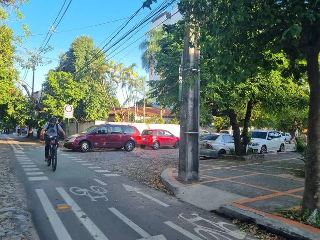 Un ciclista circula en bicicleta equipado con casco y luces por la bicisenda señalizada de la calle Las Perlas en el barrio Recoleta de Asunción.