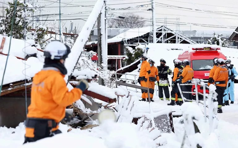 Los bomberos buscan personas desaparecidas bajo la nieve en Suzu, Prefectura de Ishikawa, Japón.