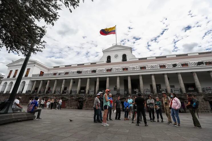 Ciudadanos ecuatorianos caminan a las afueras del Palacio de Gobierno en Quito (Ecuador).