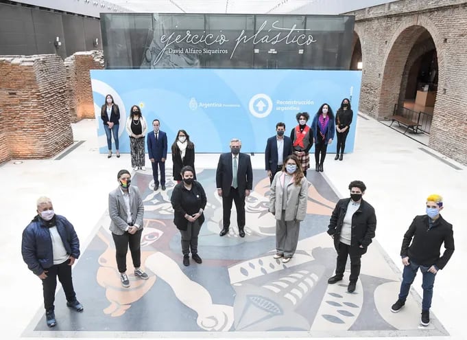 El presidente Alberto Fernández (en el centro) y otras autoridades y miembros de organismos sociales posan emulando una "x", este miércoles en el Museo del Bicentenario de la Casa Rosada.