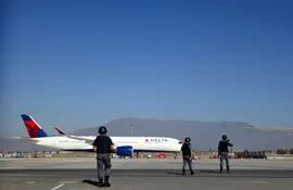 Agentes de Policía se aproximan al avión de Delta Air Lines en la pista del aeropuerto internacional de Santiago de Chile Arturo Merino Benitez.