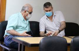 Ramón González Daher y su hijo Fernando González Karjallo charlan durante un receso, en la sala de juicios orales.