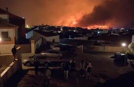 Vecinos de Zalamea la Real observan las llamas del incendio que desde el pasado jueves afecta a la sierra de Huelva, con inicio en la localidad de Almonaster la Real. Un centenar de vecinos de Zalamea la Real han tenido que ser desalojados.