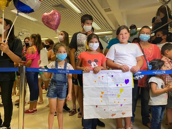 Niños esperan a sus familiares que llegan desde otros países hoy en el aeropuerto Silvio Pettirossi.
