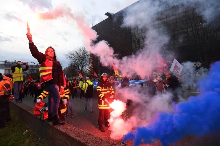 Sindicalistas con bengalas bloquean el tráfico en protesta contra la reforma del sistema de pensiones que el gobierno francés impulsa.