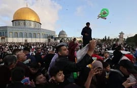 Musulmanes intercambian regales en las inmediaciones de la mezquita de Al Aqsa, en Jerusalén, este viernes.