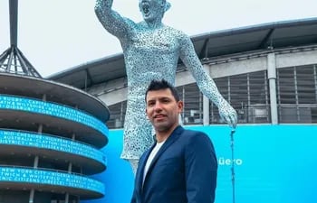 Sergio "Kun" Agüero posa frente a su estatua a un costa del estadio del Manchester City.