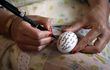 Una mujer escribe su mensaje en un huevo durante la peregrinación anual a El Ghriba, para conmemorar el día sagrado de Lag B'Omer.