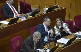 La senadora Lizarella Valiente muestra su celular al senador Gustavo Leite, también del cartismo, en la sala de sesiones del Senado.