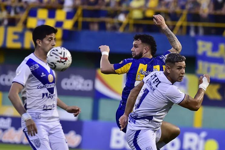 Rodrigo Alborno (expulsado) y Sergio Bareiro (anotó el primer gol) giran para buscar el esférico, el que  no lograron controlar.