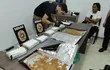 La aprehendida Lidia Ramírez Quintana observa a un agente de la Senad analizar los "panes" de cocaína que fueron encontrados dentro de su maleta, en el aeropuerto internacional "Silvio Pettirossi".