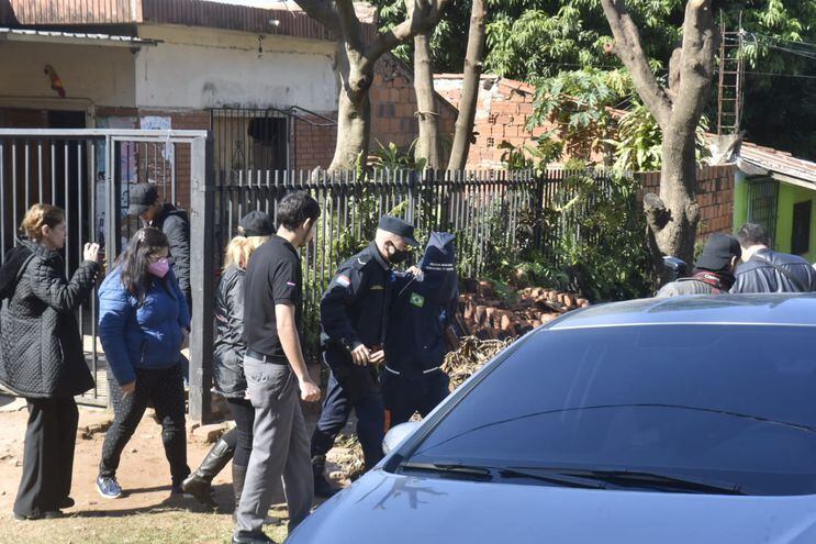 Reconstrucción del crimen de la adolescente en el barrio San Isidro, Lambaré. El hermanastro, y señalado como responsable del feminicidio, aparece con una capucha en la cabeza.