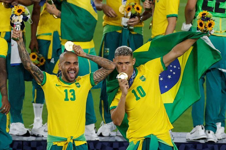 Los futbolistas de Brasil Richarlison (d) y Dani Alves (i) celebran tras conseguir la medalla de oro durante los Juegos Olímpicos 2020.