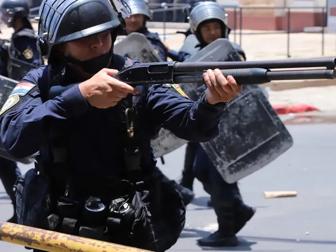 Un agente policial con una escopeta cargada con balines de goma durante las manifestaciones de ayer contra la creación de la Superintendencia de Pensiones y Jubilaciones.