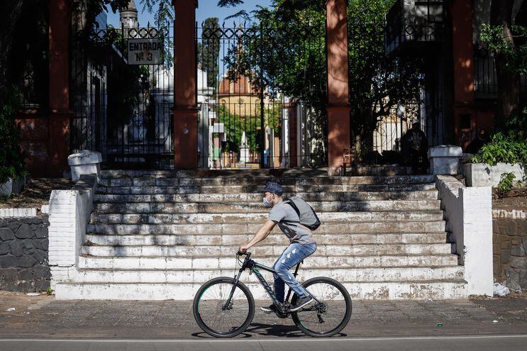 Un ciclista se traslada en bicicleta por la avenida Mariscal López, frente al cementerio de la Recoleta, en Asunción (Paraguay).