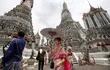 Turistas chinos vestidos con tradicionales trajes tailandeses posan en el templo Wat Arun en Bangkok, Tailandia.