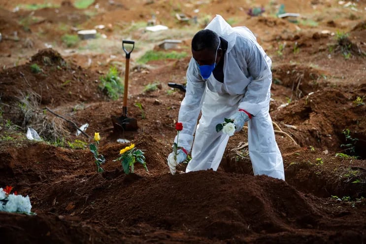 Trabajadores llevan a cabo el entierro de una víctima de la covid-19 en el Cementerio Vila Formosa el 11 de marzo de 2021, en Sao Paulo (Brasil). El país superó hoy las 2.300 muertes diarias por la enfermedad.