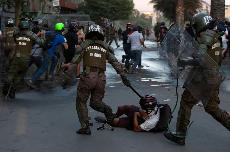 Carabineros de Chile reprimen a un manifestante durante una protesta ayer, 27 de noviembre, en Santiago.