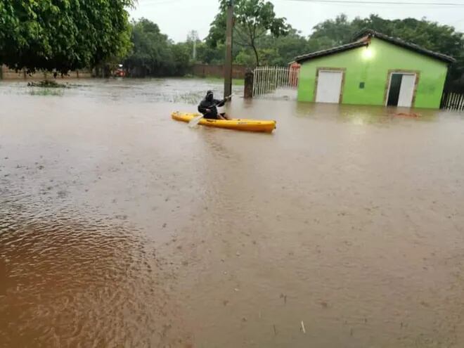 Una persona recorre en canoa una zona inundada de Coronel Oviedo, este domingo.