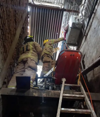 Bomberos Voluntarios trabajan en el rescate del cadáver de un hombre electrocutado en el Mercado de Abasto