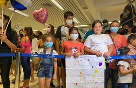 Niños esperan a sus familiares que llegan desde otros países hoy en el aeropuerto Silvio Pettirossi.