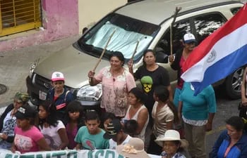 Mujeres portan palos al marchar sobre la calle Yegros de Asunción.