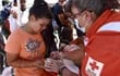 Una voluntaria de la Cruz Roja reparte alimentos a migrantes hoy, en Ciudad Juárez, Chihuahua (México).