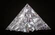 Una pirámide hecha con billetes de cien dólares, sobre un fondo negro.
