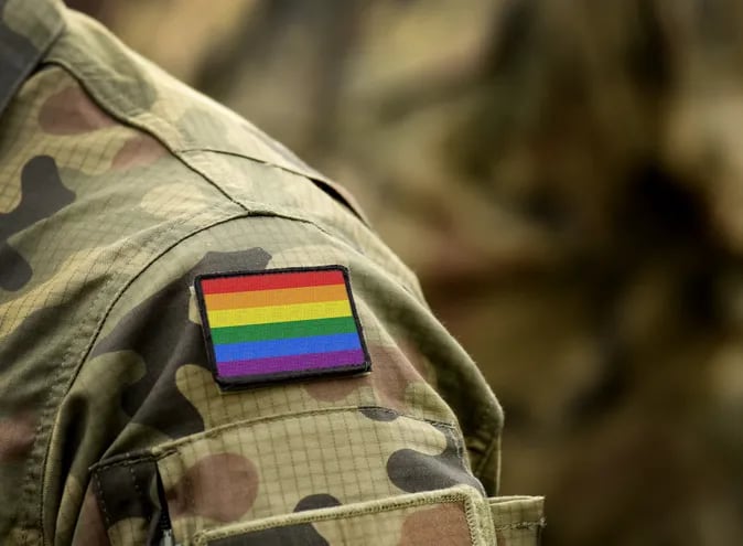 Un hombre con uniforme militar camuflayado con una insignia de arcoiris
