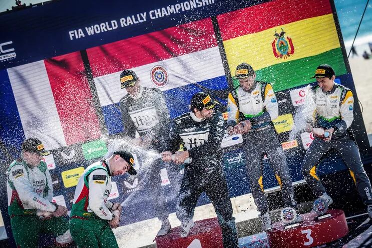 Baño de champán para los vencedores en la WRC3, Diego Domínguez Bejarano y Rogelio Peñate, en Portugal. En el fondo la bandera paraguaya.