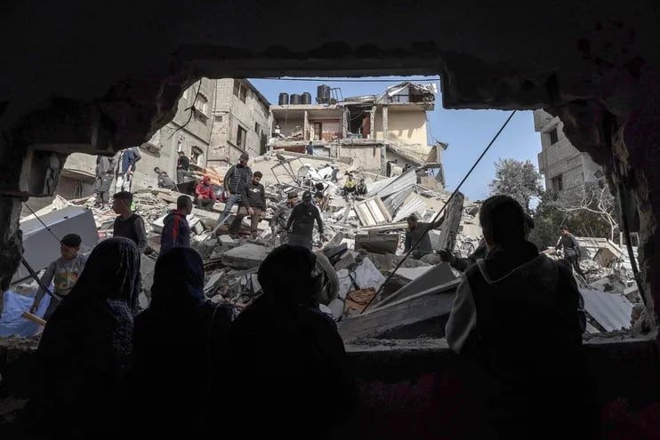 Varias personas revisan los escombros de edificios destruidos por un bombardeo israelí en Rafah, en el sur de la Franjade Gaza, el miércoles.