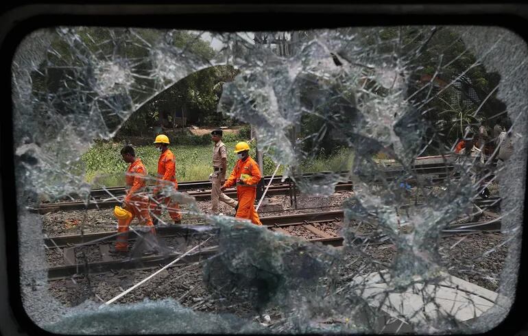 Miembros del Servicio de Rescate de la Fuerza Nacional de Respuesta a Desastres trabajan el sábado en el lugar donde se registró el accidente de tren en el distrito de Balasore, en el estado oriental de Odisha de la India.