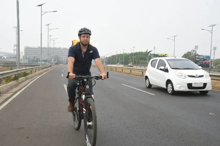 Un ciclista circula por la avenida Ñu Guasu y comparte el espacio con otros vehículos a motor.