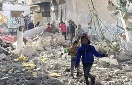 Varias personas entre los escombros de una mezquita destruida en Rafah, en el sur de la Franja de Gaza, el lunes.