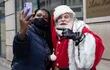 Una transeúnte se toma una selfie con el Papá Noel de The New York .