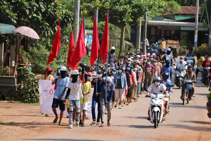 Manifestantes sosteniendo banderas mientras marchan en una protesta contra el golpe militar en el municipio de Launglone, en el distrito Dawei de Myanmar.
