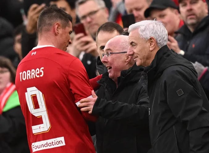 Liverpool Legends' manager Sven-Goran Eriksson (C) and Liverpool Legends' manager Ian Rush (R) congratulate Liverpool Legends' striker Fernando Torres as leaves the pitch after being substituted off during the Legends football match between Liverpool Legends and Ajax Legends at Anfield in Liverpool, north-west England on March 23, 2024. (Photo by Oli SCARFF / AFP)