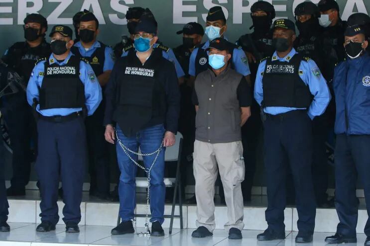 El expresidente de Honduras, Juan Orlando Hernandez (2do de la izq., encadenado) antes de su extradición a Estados Unidos.