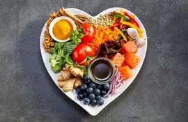 Plato en forma de corazón con diferentes tipos de alimentos saludables.