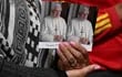 Un católico sostiene dos estampas con la figura del papa emérito Benedicto XVI durante una eucaristía celebra luego de su muerte.