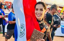 Mirna Pereira, esposa y co-piloto de Óscar Santos, festejando con la bandera paraguayo en el Rally do Sertões.