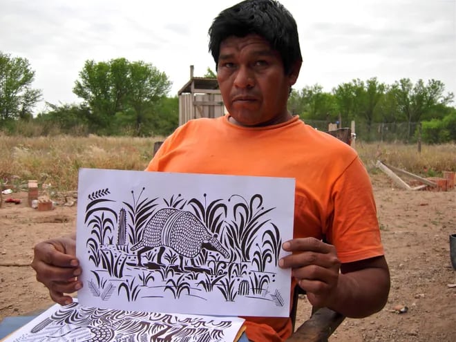 Clemente Juliuz sosteniendo uno de sus dibujos.