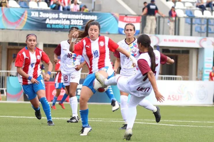 La “10” paraguaya Erika Cartamán, en un peligroso cruce de piernas contra una rival venezolana, en la puja por la pelota.