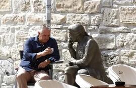 Zagreb (Croatia), 13/09/2022.- A man sits at cafe bar haveing a coffee next to a sculpture of Croatian scientist Rudjer Boskovic, in downtown Zagreb, Croatia, 13 September 2022. Zagreb installed sculptures of 13 famous Croatians from the past in the gardens of caffes in the center, aimed to be a new tourist ataraction. (Croacia) EFE/EPA/ANTONIO BAT
